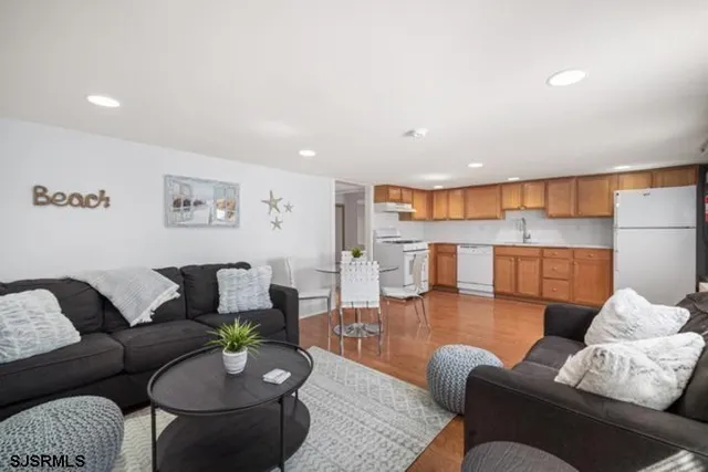 a living room with furniture and a view of kitchen