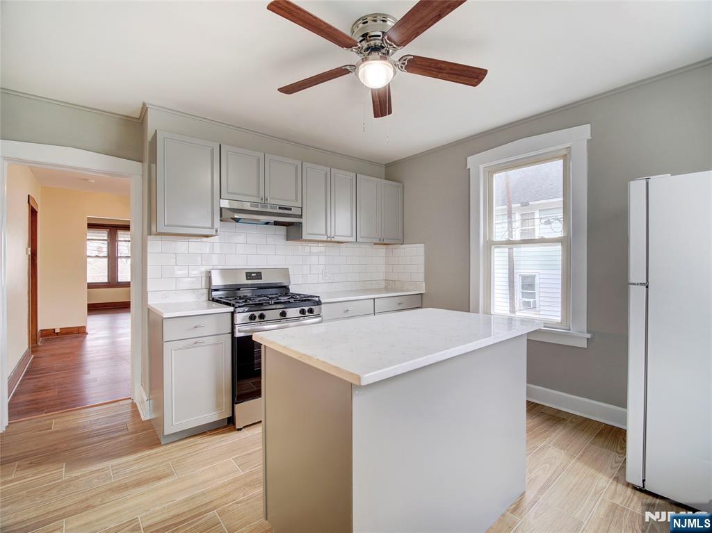140 Westervelt Avenue Hawthorne, NJ 07506 - Photo 5 of 36 a kitchen with stainless steel appliances a stove a sink and a refrigerator