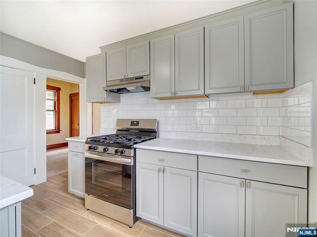 140 Westervelt Avenue Hawthorne, NJ 07506 - Photo 6 of 36 a kitchen with white cabinets and a stove top oven
