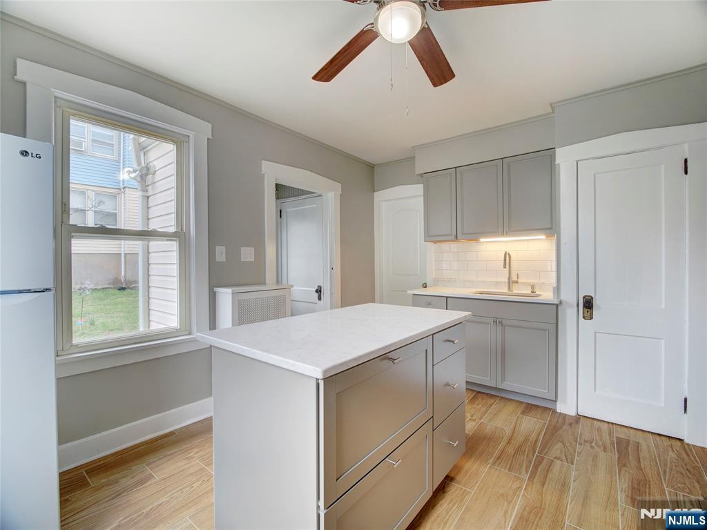 140 Westervelt Avenue Hawthorne, NJ 07506 - Photo 7 of 36 a kitchen with a stove a sink and dishwasher with wooden floor
