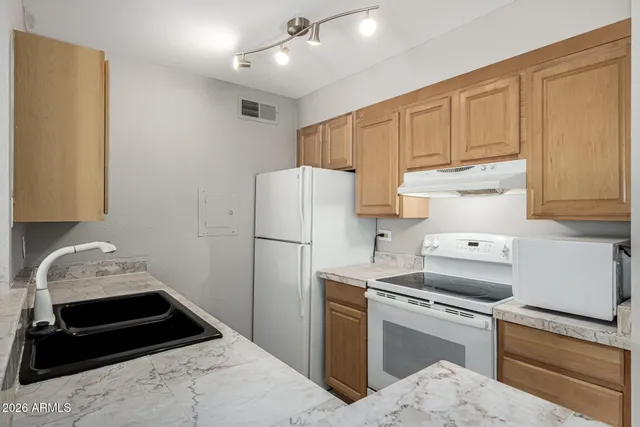 a kitchen with a refrigerator sink and cabinets
