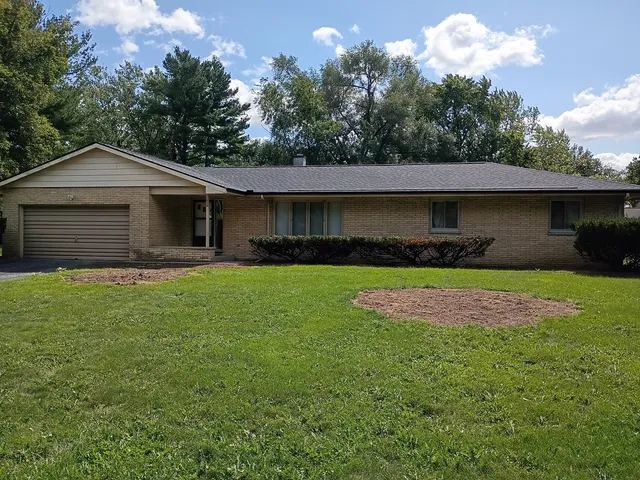 a front view of a house with a garden and plants