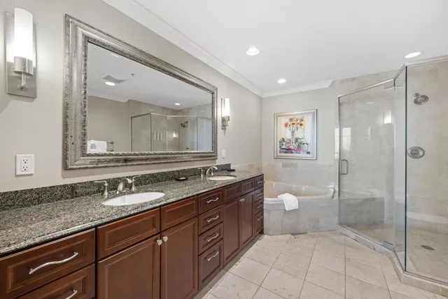 a bedroom with a large bed and a chandelier fan
