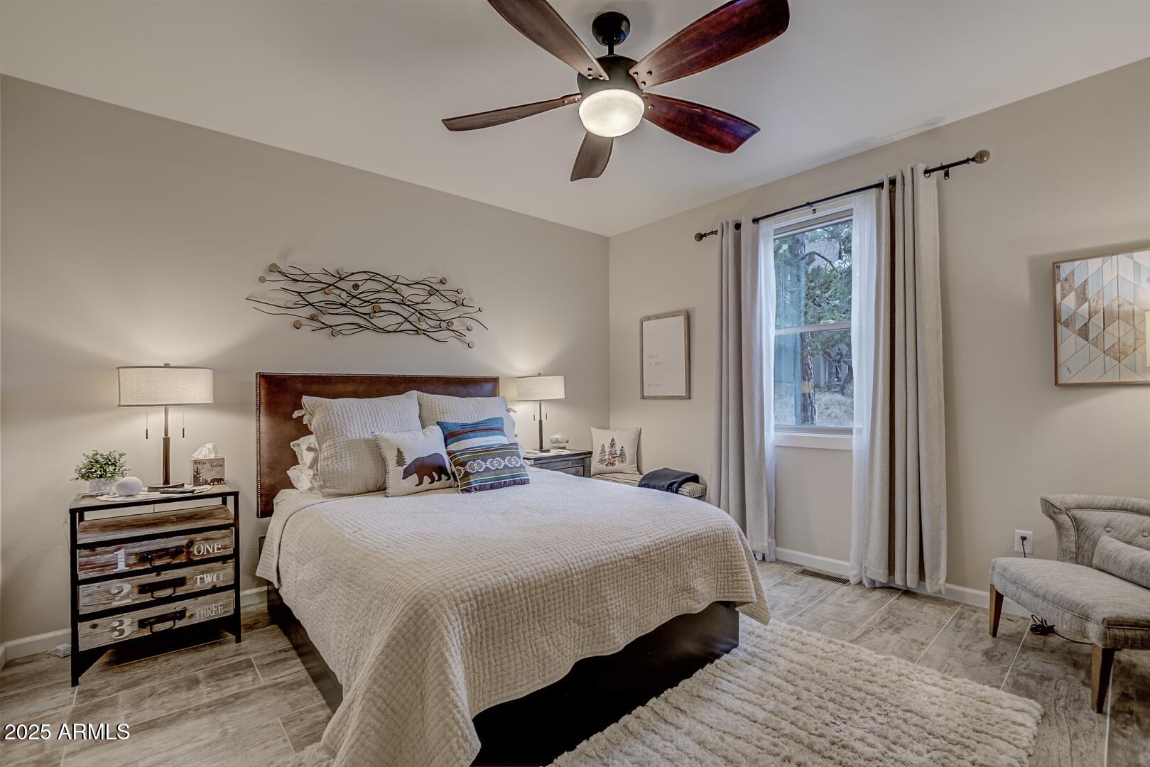 5076 Juniper Loop Pine, AZ 85544 - Photo 19 of 68 a bedroom with a bed and a chandelier