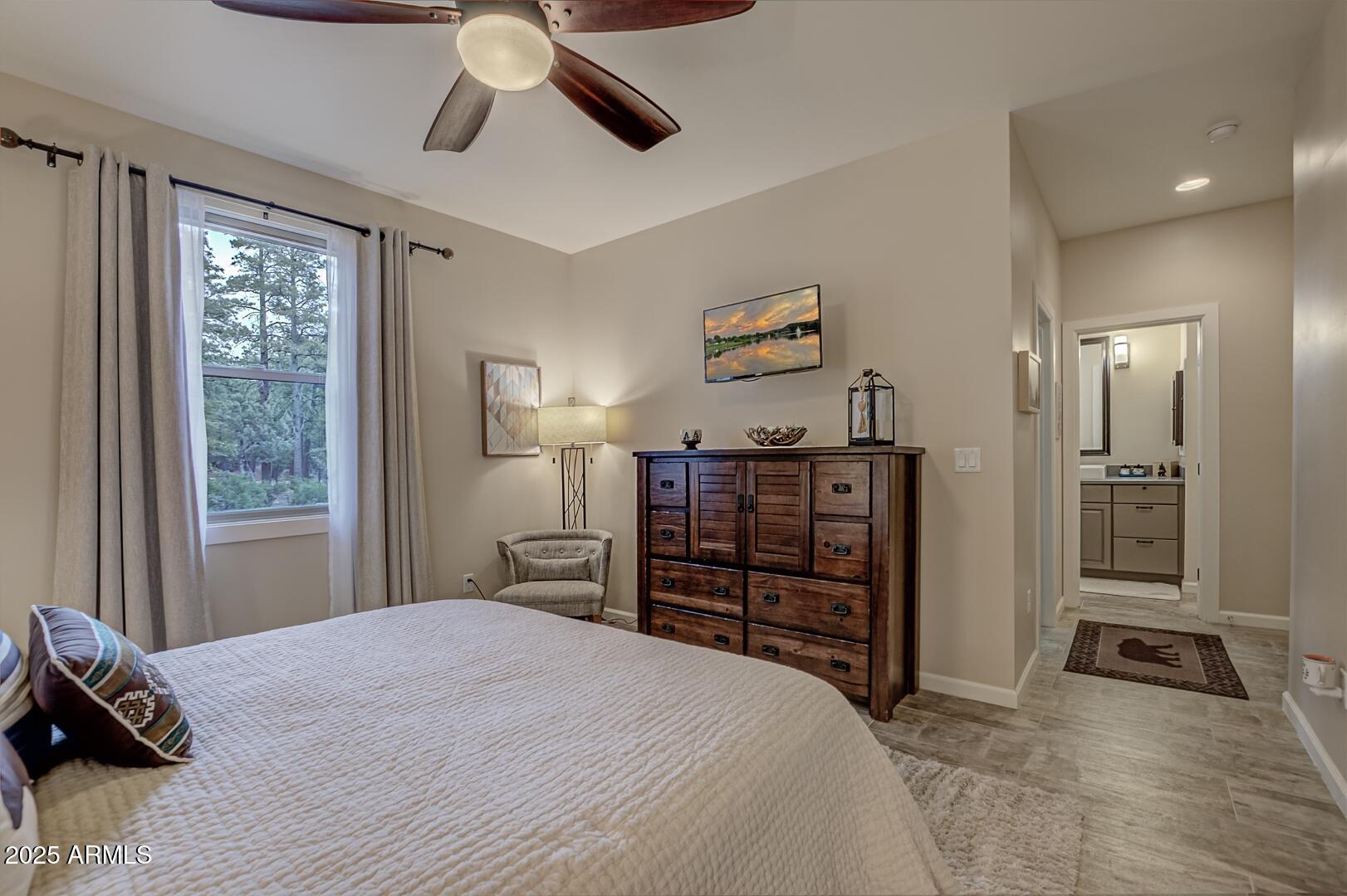 5076 Juniper Loop Pine, AZ 85544 - Photo 24 of 68 a bedroom with a bed and a chandelier