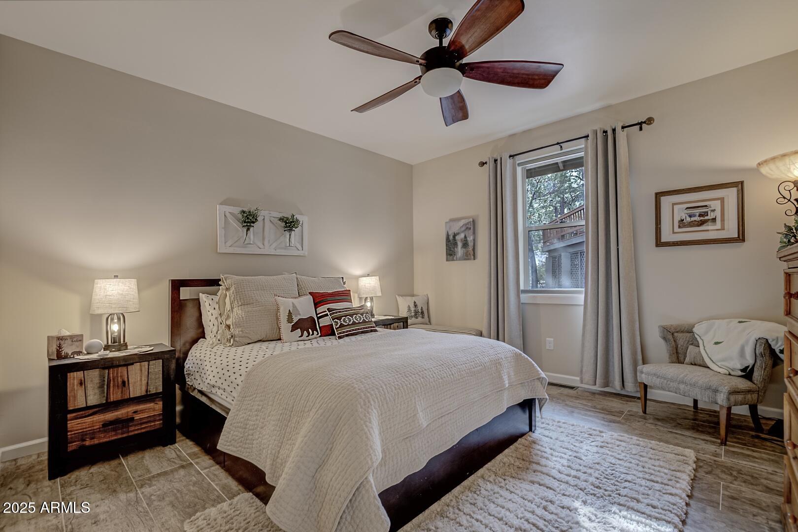 5076 Juniper Loop Pine, AZ 85544 - Photo 25 of 68 a bedroom with a bed and wooden floor