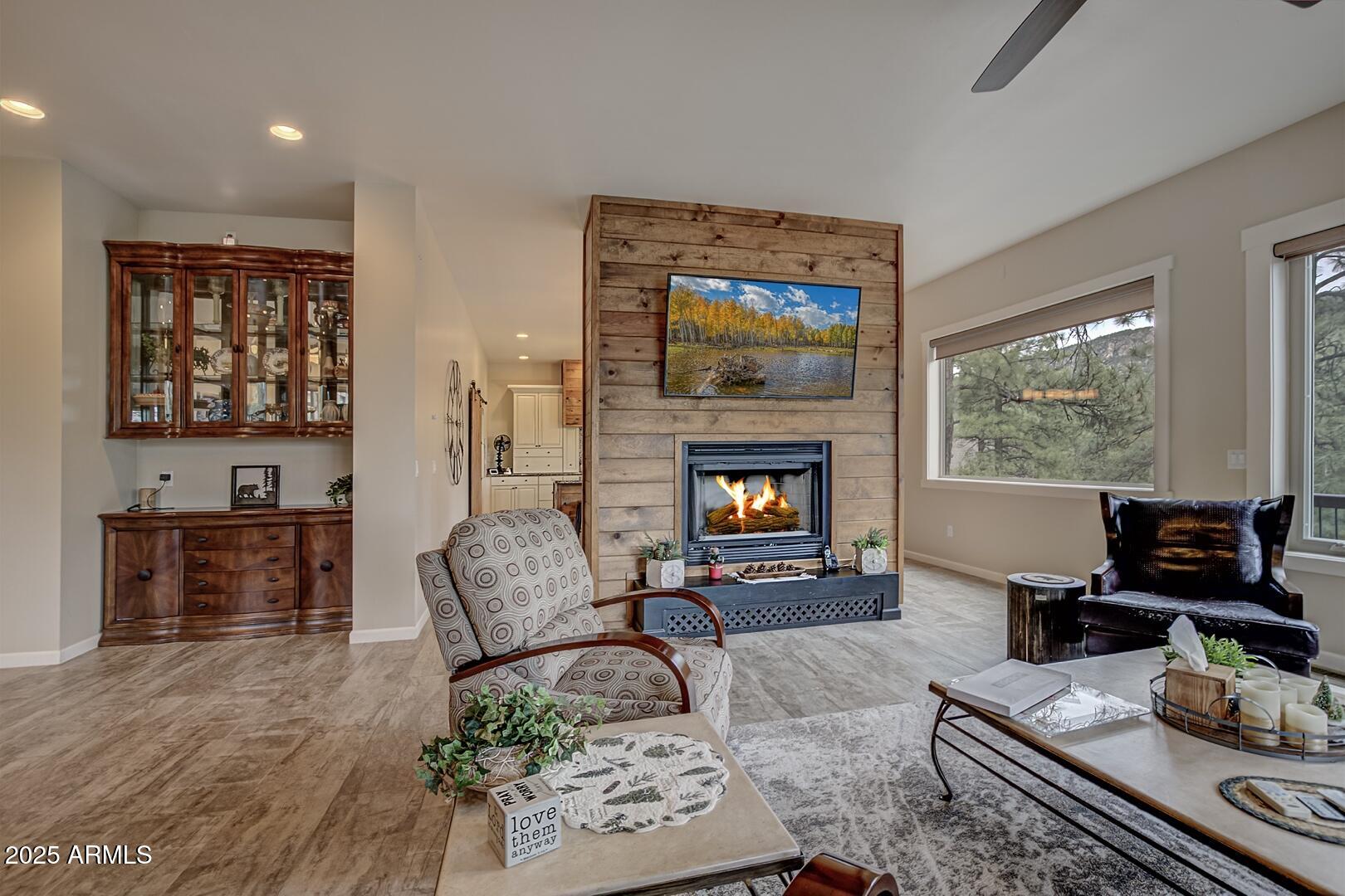 5076 Juniper Loop Pine, AZ 85544 - Photo 4 of 68 a living room with furniture a flat screen tv and a fireplace