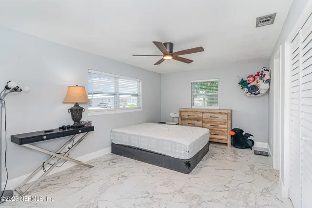 a bedroom with a bed window and painting on the wall