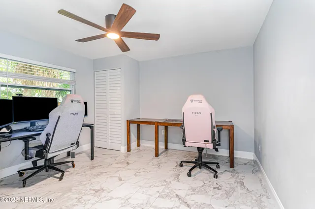 a view of a workspace with furniture and a window