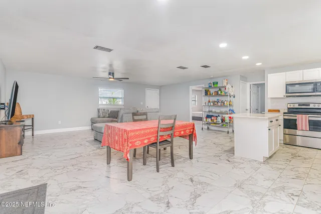 a room with stainless steel appliances kitchen island granite countertop furniture and a kitchen view