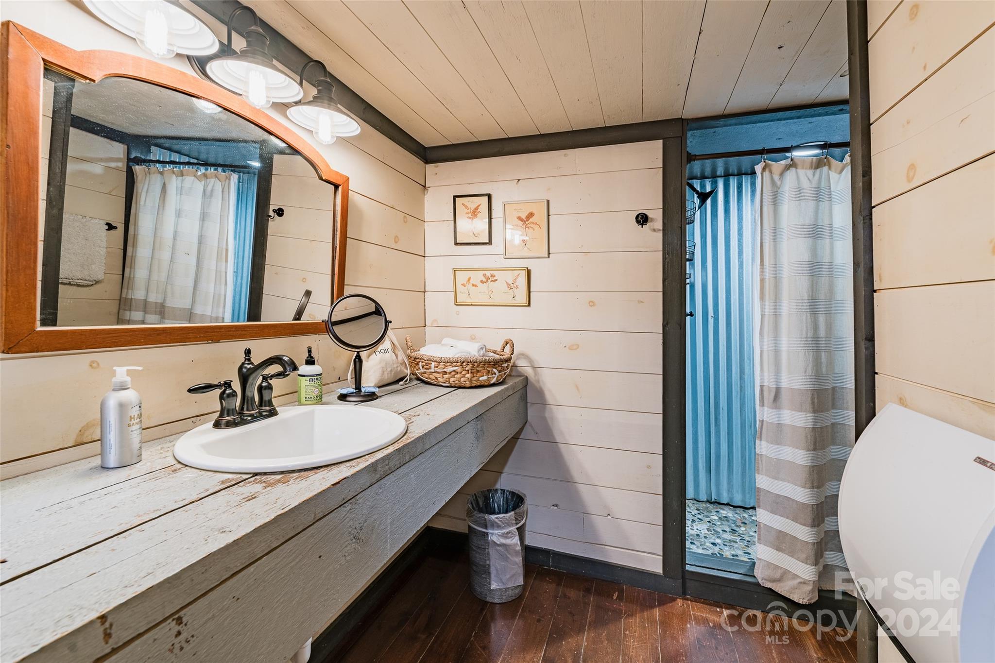 62 Weeping Cherry Forest Road Fairview, NC 28730 - Photo 20 of 48 a bathroom with a granite countertop sink a mirror and shower