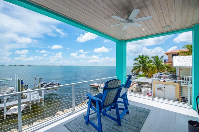 a kitchen with stainless steel appliances kitchen island granite countertop a stove top oven a sink a dining table and chairs with wooden floor