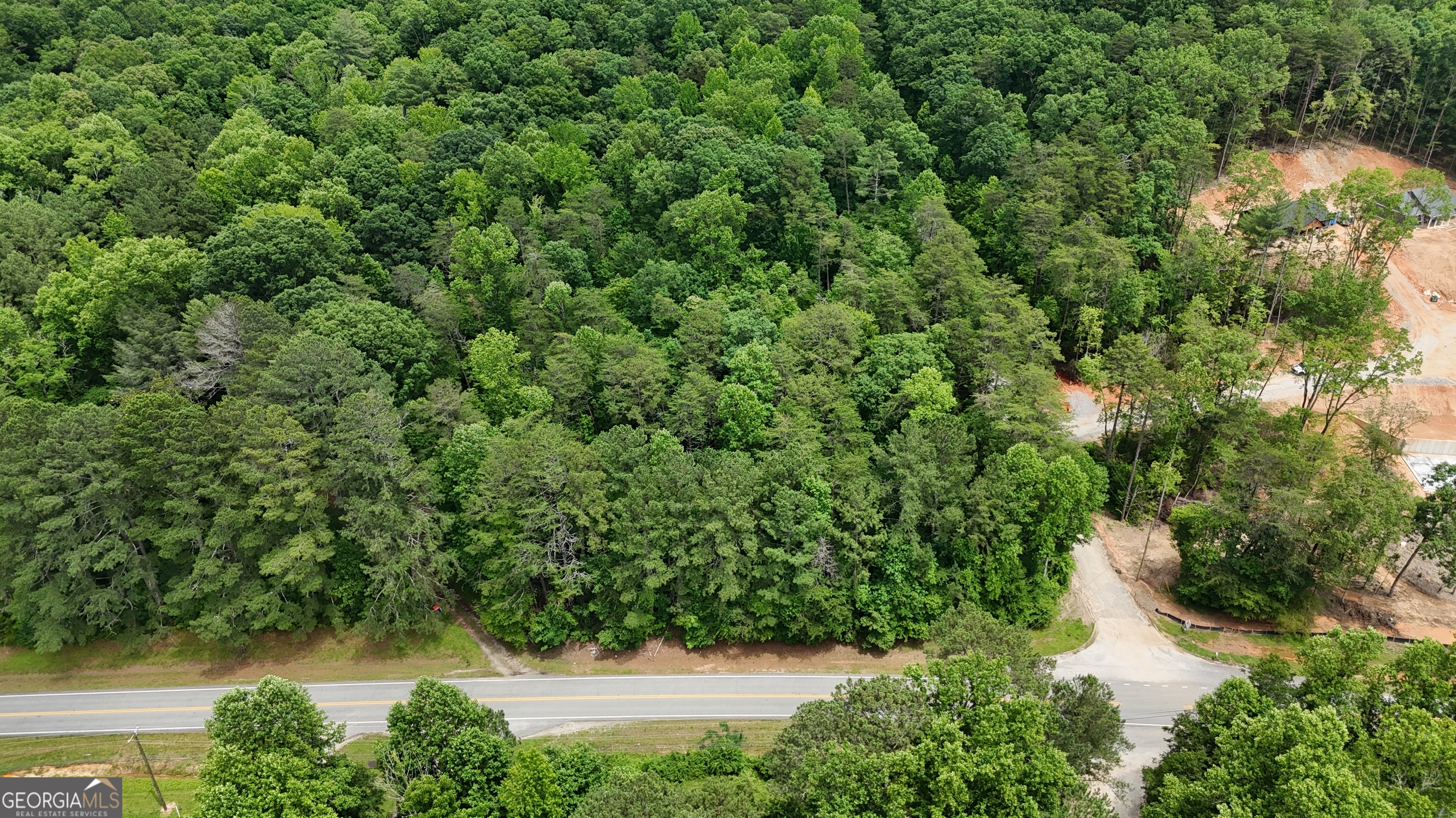 an aerial view of residential house with outdoor space and trees all around