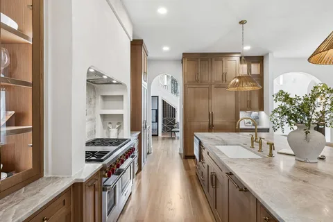 a view of a refrigerator in kitchen and an empty room