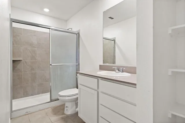 a bathroom with a shower sink vanity mirror and toilet