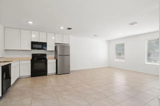 a kitchen with granite countertop a refrigerator stove and microwave