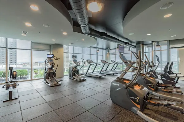 a gym room with gym equipment and a large window