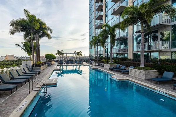 a view of swimming pool with outdoor seating and city view