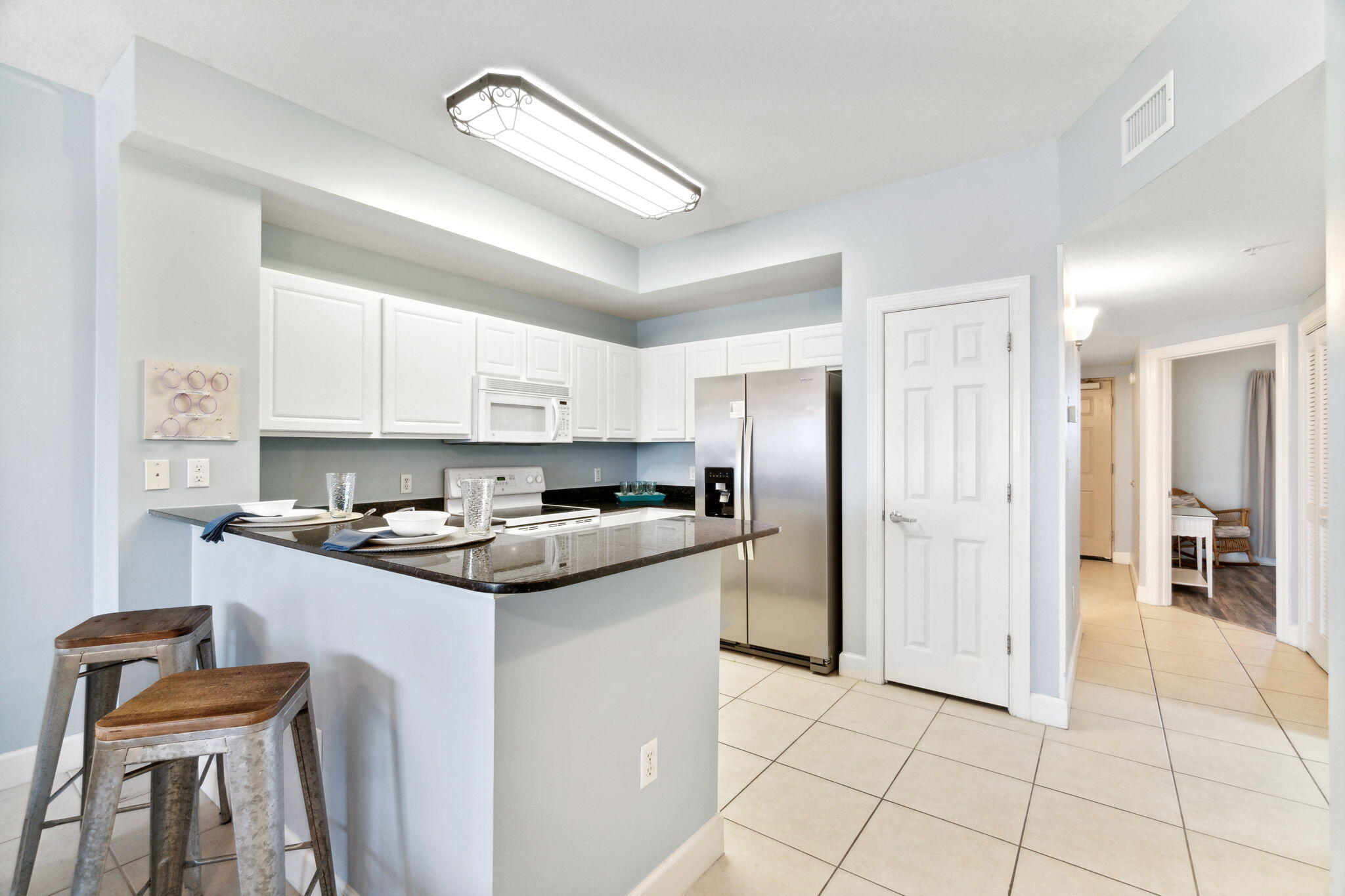 14825 Front Beach Road, Unit 1204 Panama City Beach, FL 32413 - Photo 8 of 13 a kitchen with stainless steel appliances granite countertop a stove a sink and a refrigerator