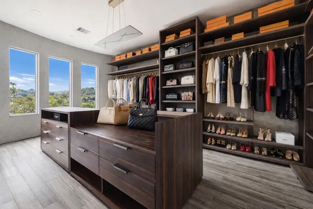 a view of walk in closet with clothes and shoes