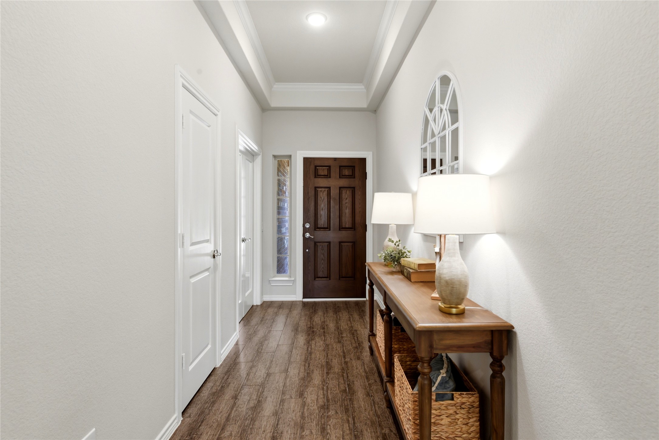 17834 Maple Ash Drive Spring, TX 77379 - Photo 6 of 50 This photo shows a welcoming entryway with warm wood flooring and a dark wooden front door.