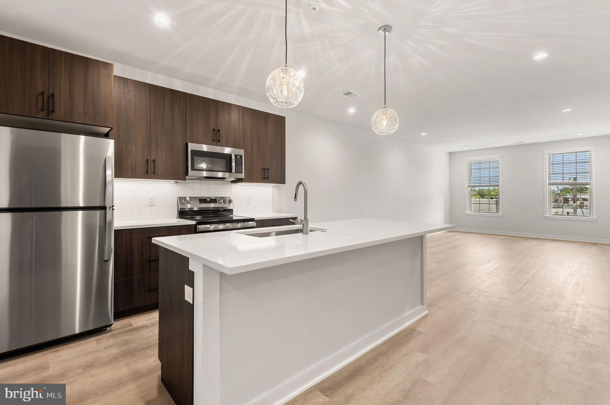 a kitchen with kitchen island a sink stainless steel appliances and window