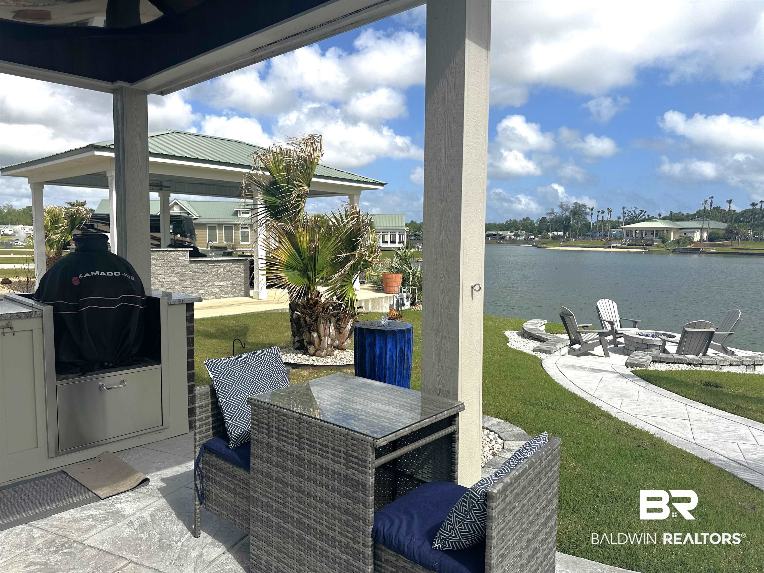 28058 Migratory Way, Unit 100 Elberta, AL 36530 - Photo 26 of 83 View of patio / terrace featuring a water view, a grill, a gazebo, outdoor dining area, and an outdoor fire pit