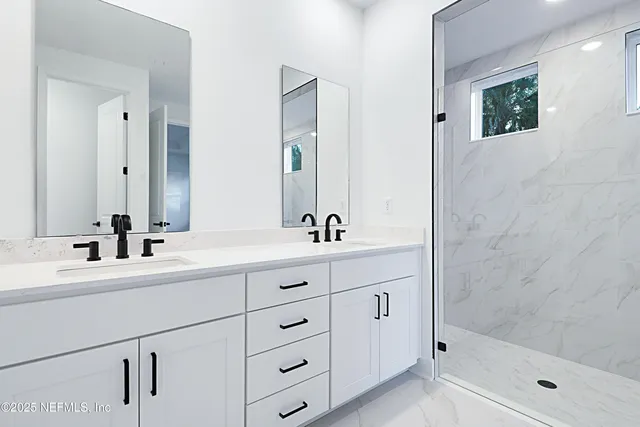 a bathroom with double sink and a mirror