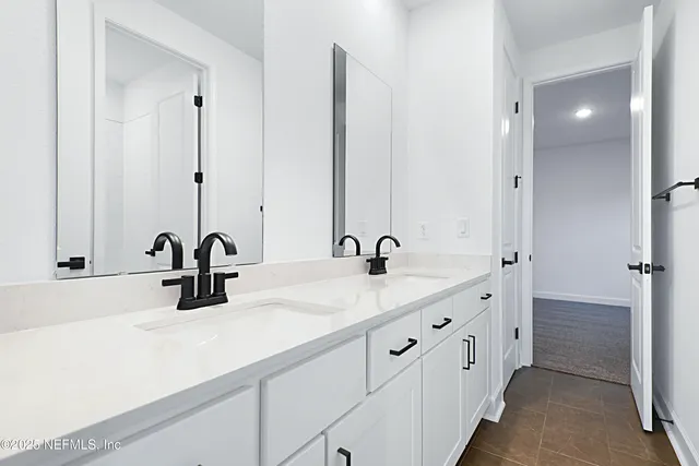 a bathroom with double sink and a mirror