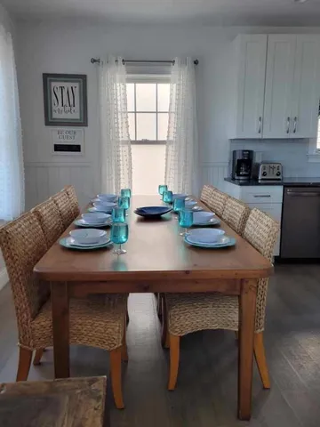 a kitchen with granite countertop a table chairs and wooden floor