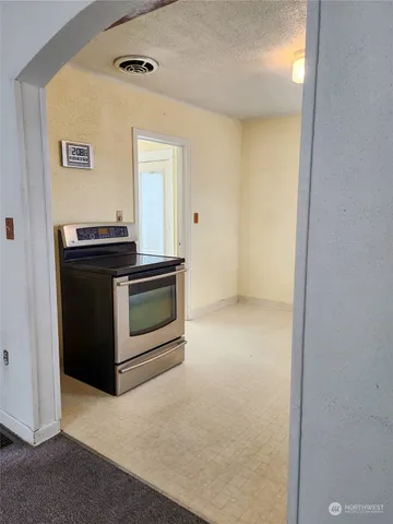a view of a kitchen with a stove cabinets and a hallway