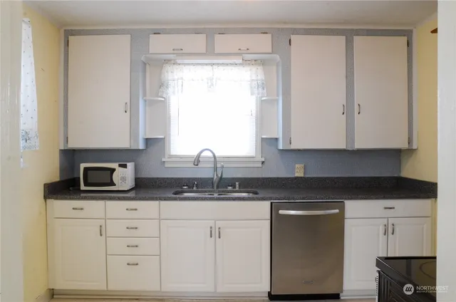 a kitchen with granite countertop white cabinets and white appliances