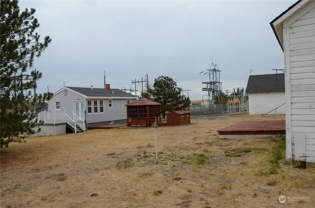 a view of a small house with wooden fence