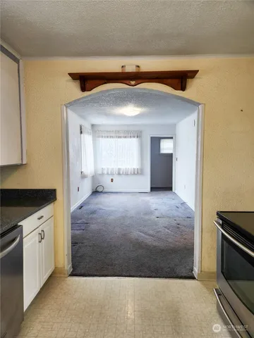 a view of an empty room with cabinet and a fireplace