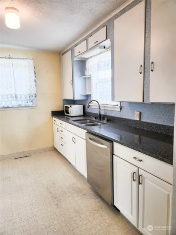 a kitchen with granite countertop a sink and a stove