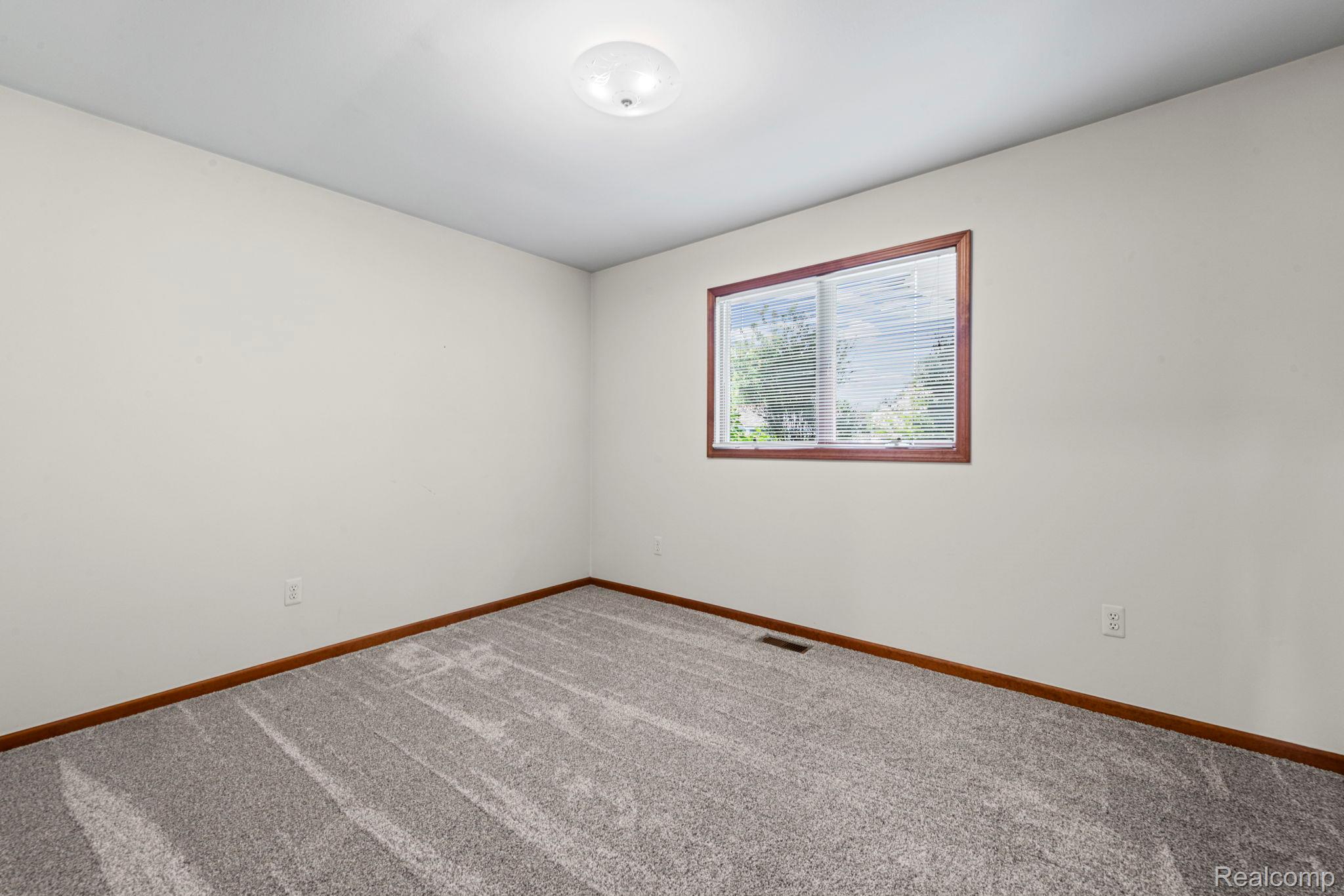 21580 Georgetown Road Trenton, MI 48183 - Photo 20 of 36 Neutral wall color, gray patterned carpeting, and dark wood-finish baseboards