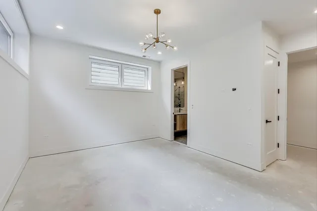 en empty room with windows and chandelier