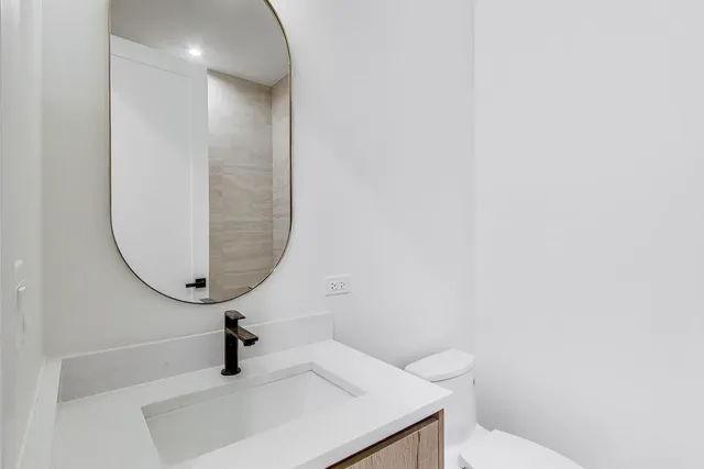 a bathroom with a sink a toilet and a mirror