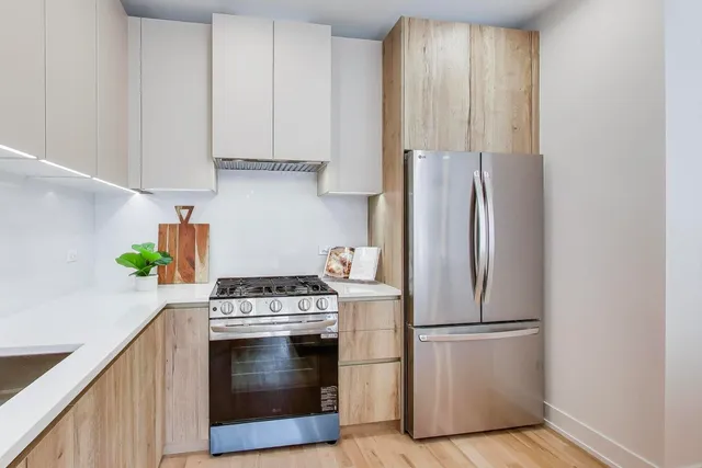 a kitchen with stainless steel appliances granite countertop a refrigerator sink and stove