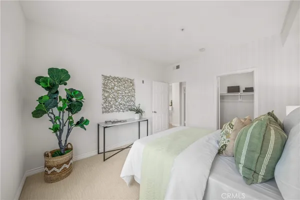 a bedroom with a bed and a potted plant