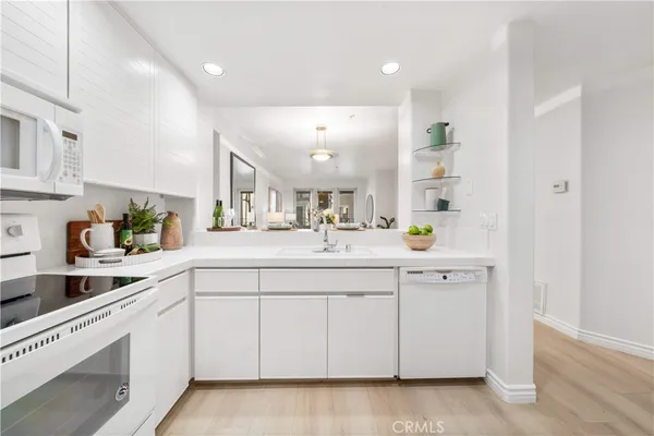 a large white kitchen with cabinets and a sink