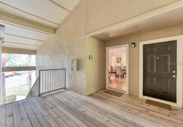 a view of a hallway with wooden floor and a window