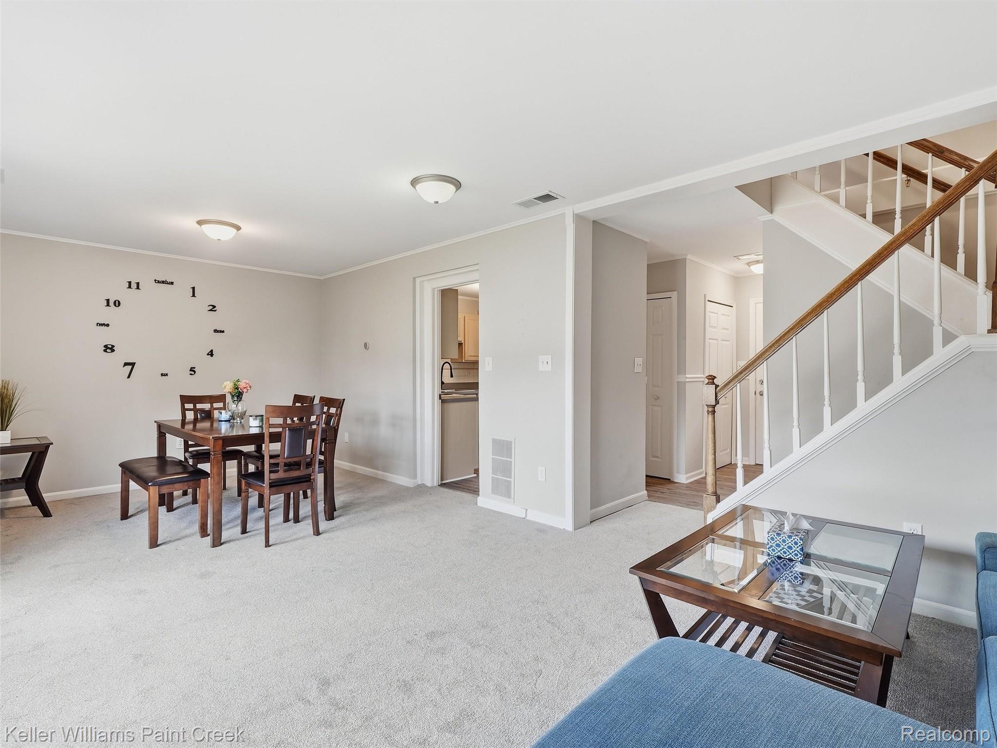 1208 Lear Court Rochester, MI 48307 - Photo 12 of 28 Light-colored carpeting throughout, a wood-finish staircase with white balusters, and a dining area with overhead lighting