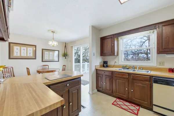 a kitchen with stainless steel appliances granite countertop a stove a sink dishwasher and cabinets with wooden floor