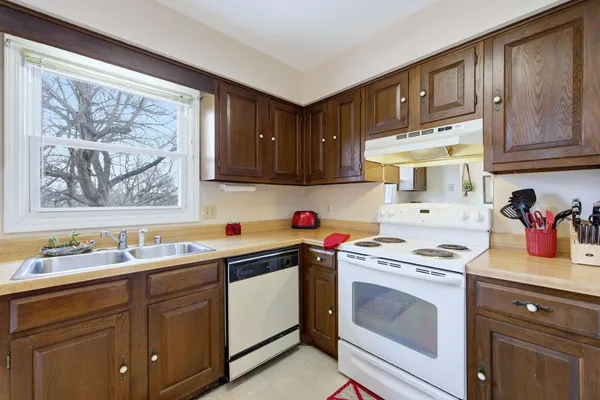 a kitchen with stainless steel appliances granite countertop a sink a refrigerator and a stove