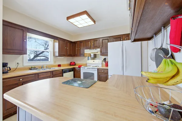 a kitchen with stainless steel appliances granite countertop a refrigerator sink stove and cabinets