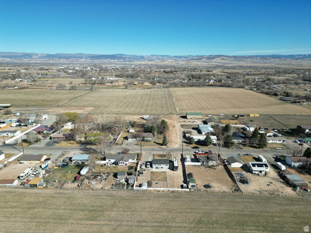 1852 East 3500th Street South Vernal, UT 84078 - Photo 32 of 46 Aerial overview of property's location with rural landscape, mountains, and rows of crops-looking north