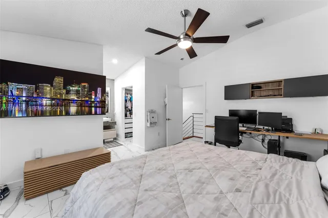 a bedroom with a bed a desk and television