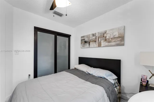 a bedroom with a bed and a painting on the wall