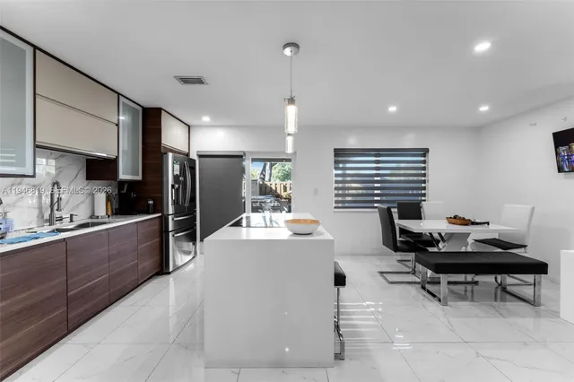 a kitchen with stainless steel appliances kitchen island granite countertop a sink and cabinets